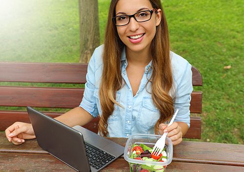 A beautiful lady with her laptop and healthy food