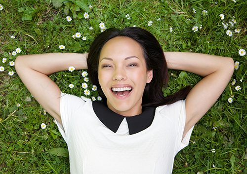 Young teen smiling while lying on the grass