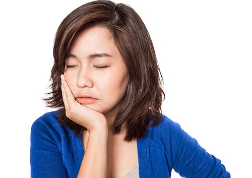 A woman experiencing a headache- TMJ Dentistry