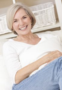 Portrait of an attractive elegant senior woman relaxing at home on a sofa.