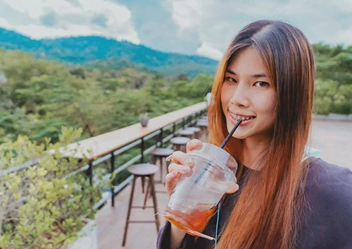 The girl is drinking cool drinks on a hot day