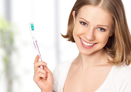 A beautiful woman holding a toothbrush with whitening toothpaste