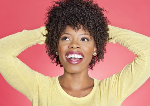 Curly woman happily smiling