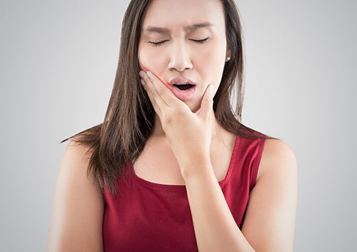 A woman suffering from a toothache.