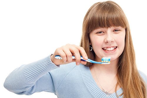 Teenage girl brushing teeth